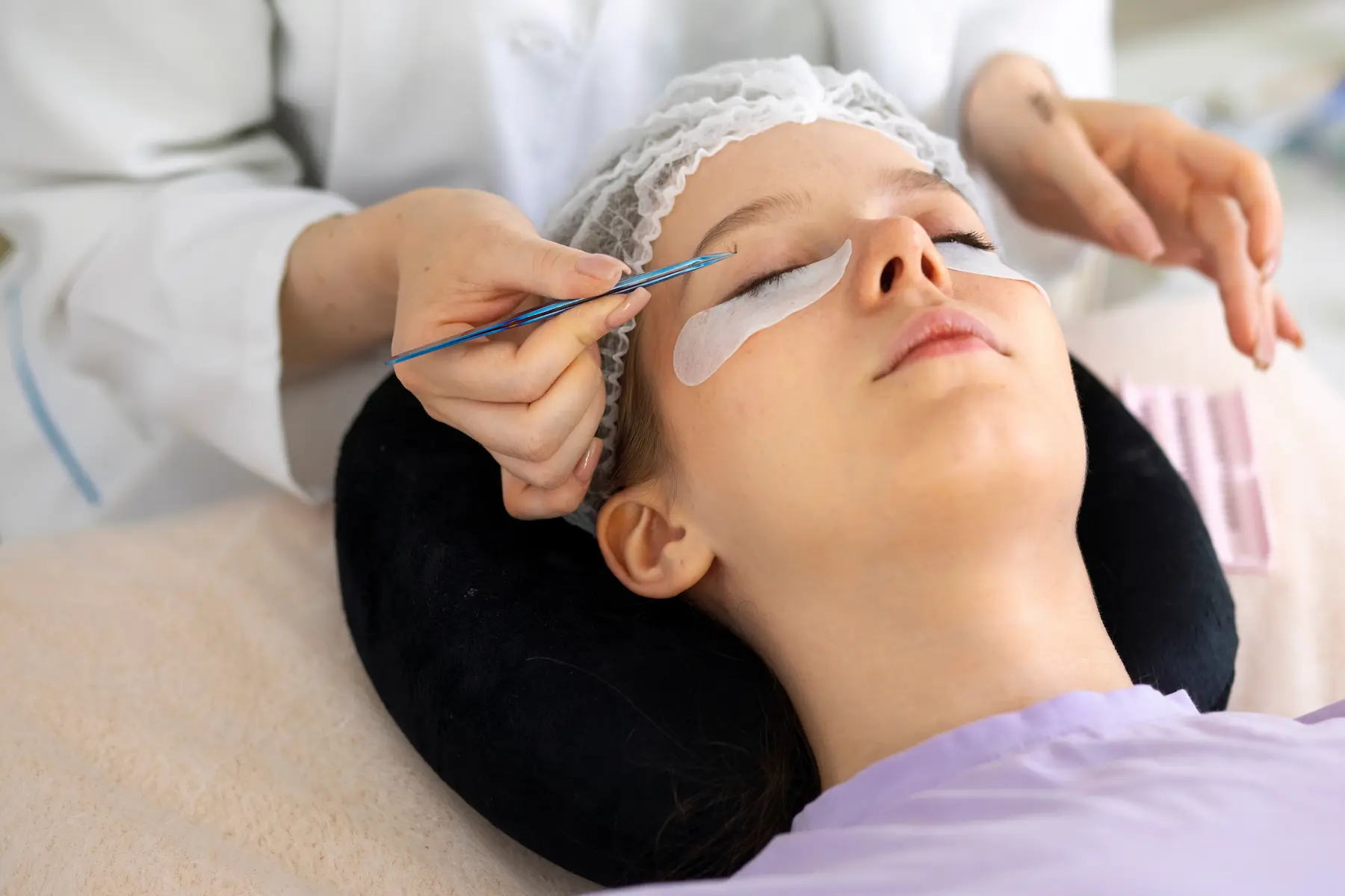 woman-wearing-eye-patches-high-angle | The Lift Bar lash extensions Nicholasville